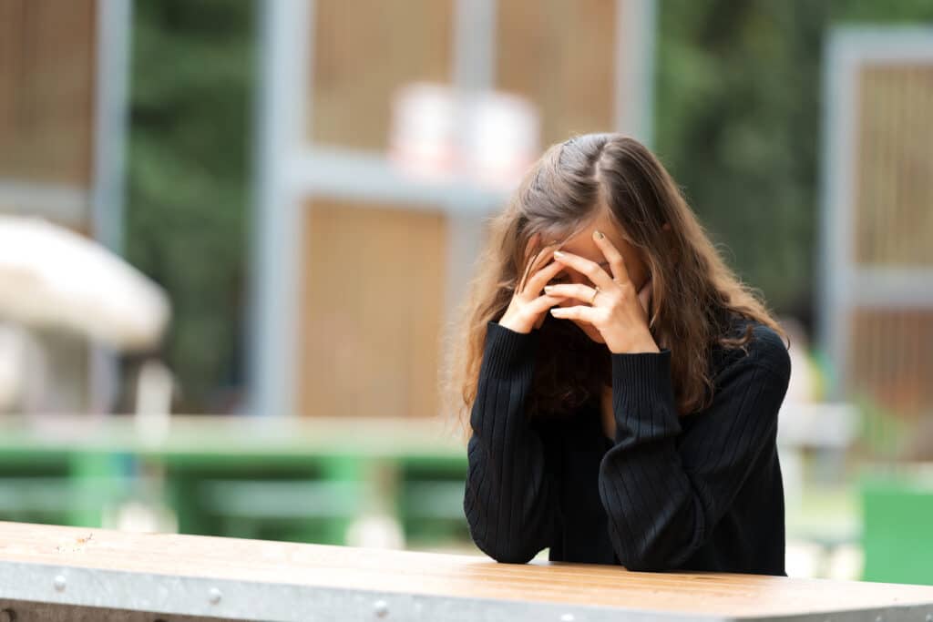 Young woman holding her head in shame.